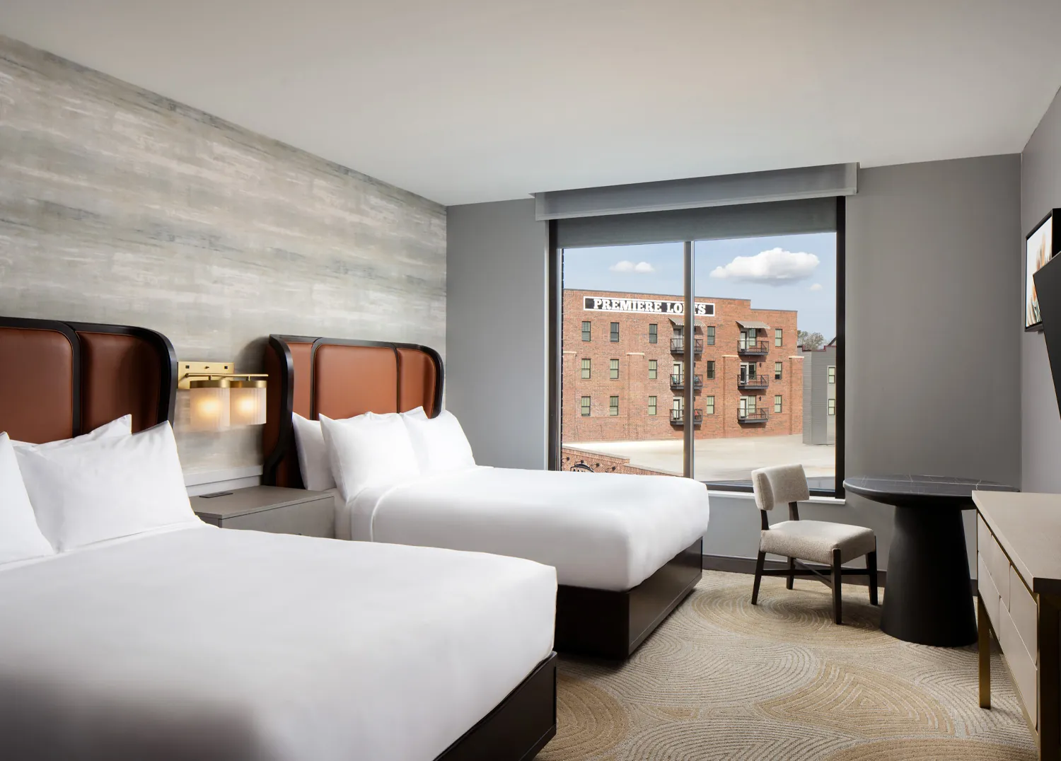 two queen beds in hotel room with city view