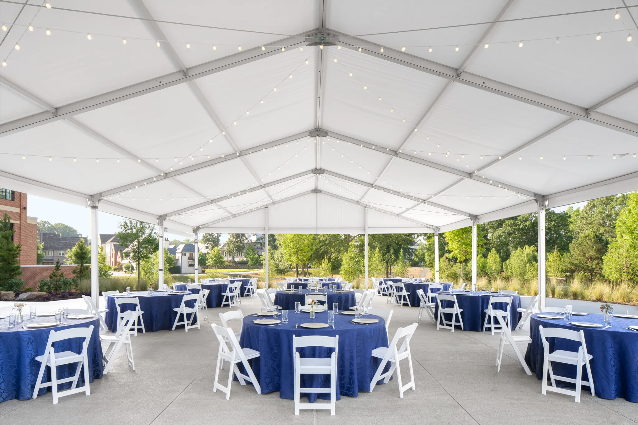A large white tent with tables and chairs